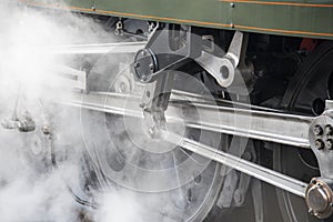 Wheel of vintage rail locomotive with steam