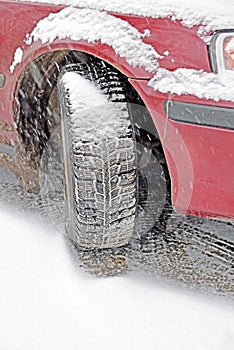 Wheel with winter automobile tire in snowfall
