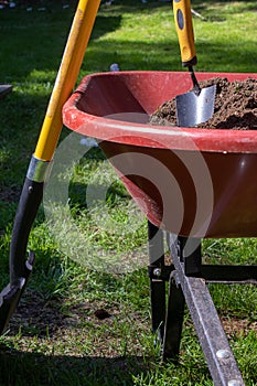 Wheelbarrow filled with dirt and a trowle