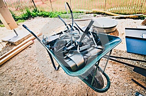 Wheelbarrow full of roofing metal waste material on construction