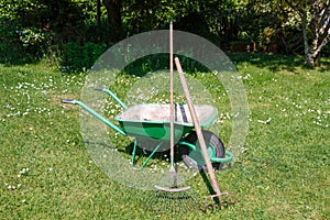 Wheelbarrow with lawn rake and claw cultivator