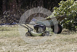 Wheelbarrow and Lawnmower in Garden