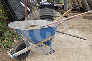 Wheelbarrow left outside with shovels