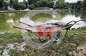 Wheelbarrows with Gardening Equipment by the Pond