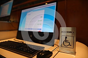 Wheelchair accessible and blind people sign placing on computer table