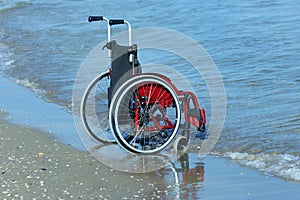 Wheelchair on Sea shore on sandy beach in summer