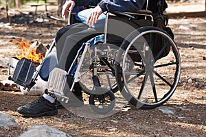 Man in a wheelchair in a park near the fire. photo