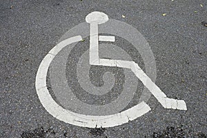 Wheelchair symbol in a disabled parking lot Old icons white on the street