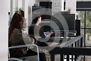 Wheelchair user typing script code on computer