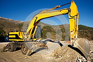 Wheeled excavator, sitting motionless in the Spanish hills.