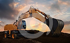 wheeled excavator at work digging soil during sunset