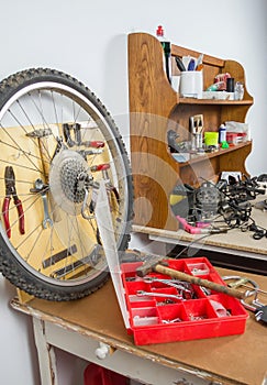 Wheels and bicycle parts over workshop table