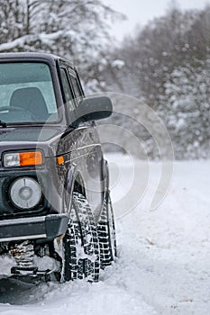 Wheels off-road car on a snowy road in the Russian outback. Winter adventures to overcome hard-to-reach forest areas