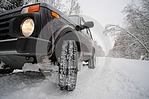 Wheels off-road car on a snowy road in the Russian outback. Winter adventures to overcome hard-to-reach forest areas