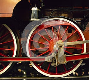 Wheels of an old red steam locomotive closeup.