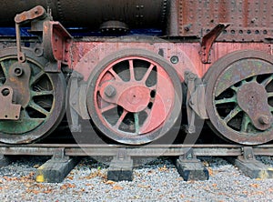 wheels on an old rusting abandoned steam locomotive with red and