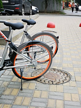 Wheels of orange bikes on the street in parking