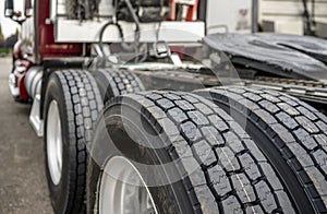 Wheels with tires on axels of big rig semi truck standing on parking lot