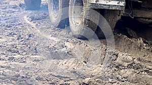 The wheels of a truck that drives through a swamp. Complex construction conditions