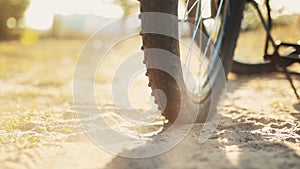 Wheelspin, bicycle rear wheel slips skids and brakes on the sand in slow motion, tire close up. Cross-country mountain