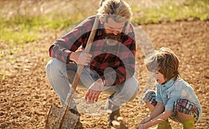 Where food comes from. Teaching son growing plants. Planting plants. Works in field. Father farmer instruct baby how to