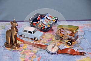 Where are we going on vacation? The symbols of the countrys on the map. Old Blue car, Thai keb, Dutch shoes, An old compass.