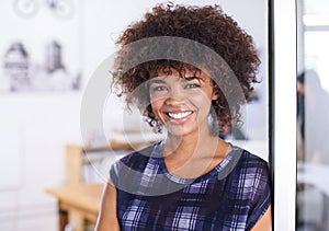 Where I belong. Portrait of a young female architect with her colleagues working in the background.