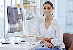 Where others fail youll prevail in time. Portrait of a young businesswoman sitting at a desk in a modern office.