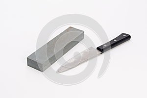Whetstone and knife on white background
