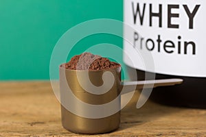 Whey Protein. Close up of scoop with chocolate powder and black