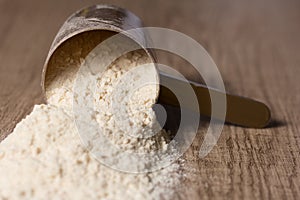 Whey Protein. Dropped scoop with vanilla powder flavour. Wooden
