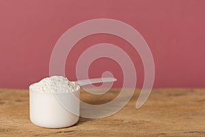 Whey Protein. Front view of white scoop with vanilla flavour pow