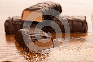 Whey protein powder and chocolate protein bar on wooden photo