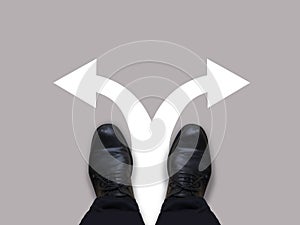 Which way - direction choices and decisions for businessman in black shoes with left and right directional arrows - business conce