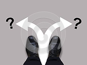 Which way - direction choices and decisions for businessman in black shoes with left and right directional arrows and question mar