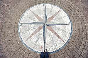 In which way? Mosaic compass rose background and woman sneakers.