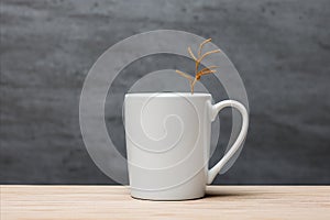 whiite neutral mug with hot branch on wooden table, copu space white mockup template photo