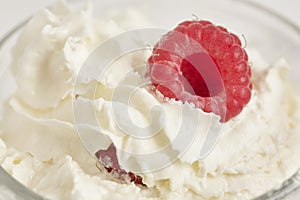 Whipped cream and fresh raspberries. Close-up