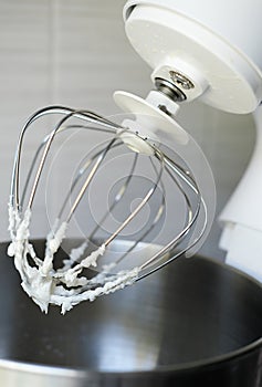 Whipped egg whites or frosting on electric mixer whisk. Baking dessert concept. vertical size