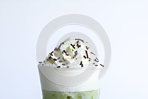 Whipping cream with chocolate sugar topping on ice matcha and green tea on white background. Sweet and delicious snack at party