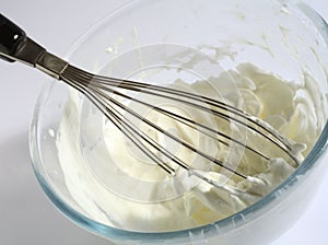 Whipping cream in a glass bowl