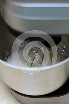 Whipping egg whites in professional kitchen mixer in a restaurant. Close-up whipped whites and sugar in a metal planetary blender