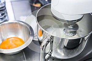 Whipping egg whites in professional kitchen`s mixer