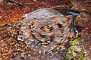 Whirlpool in water in autumn