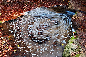 Whirlpool in water in autumn