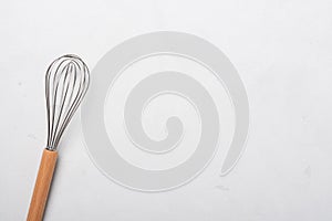 Whisk cooking egg beater mixer whisker with wooden handle on stucco table