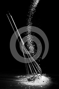 A whisk with falling flour