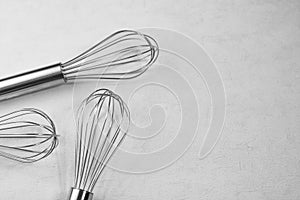 The whisk placed On the background is uneven white plaster