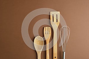 whisk and wooden spatula on brwn background copy space