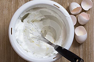 Whisked egg whites in bowl with beater photo